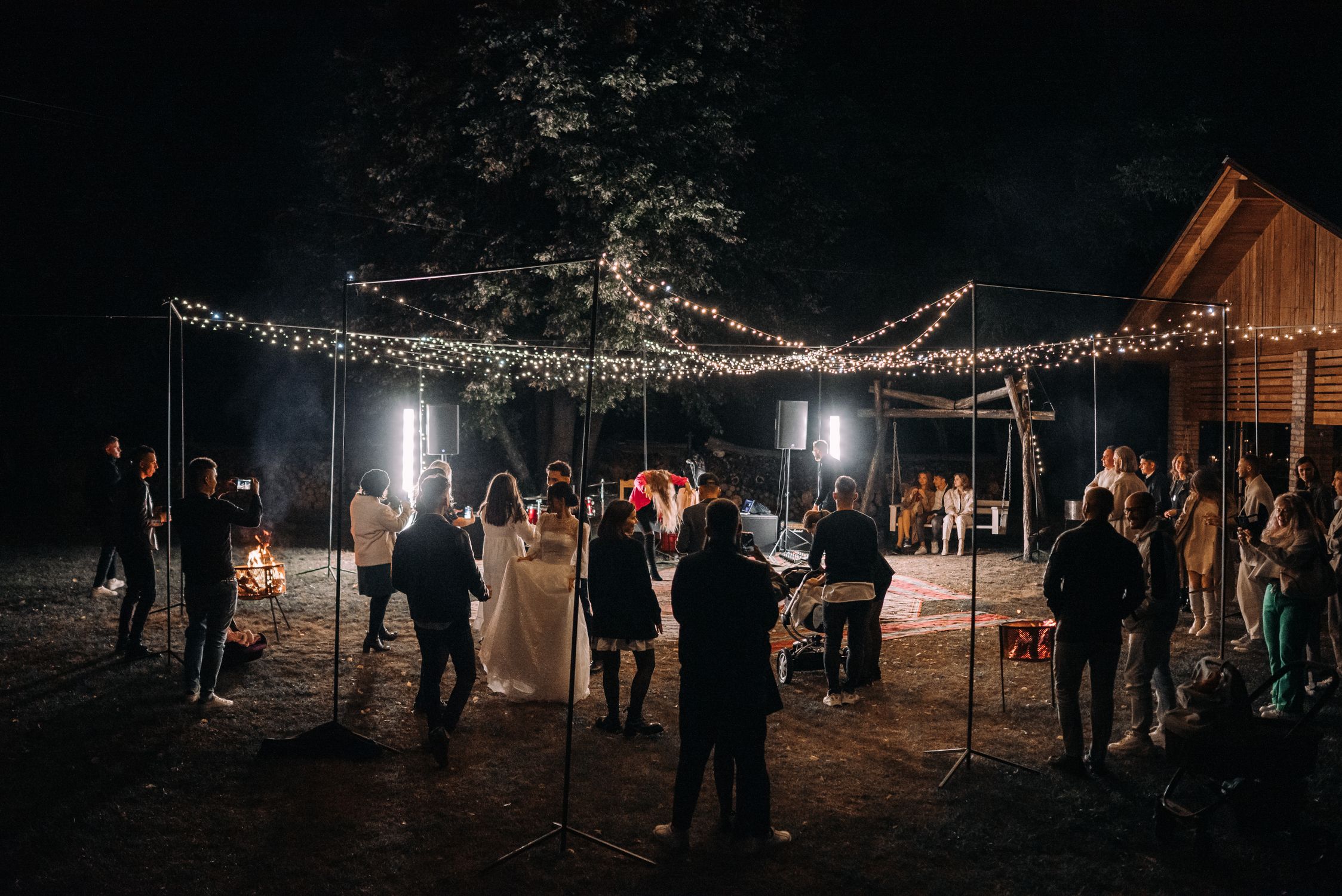 An outdoor evening wedding reception with string lights